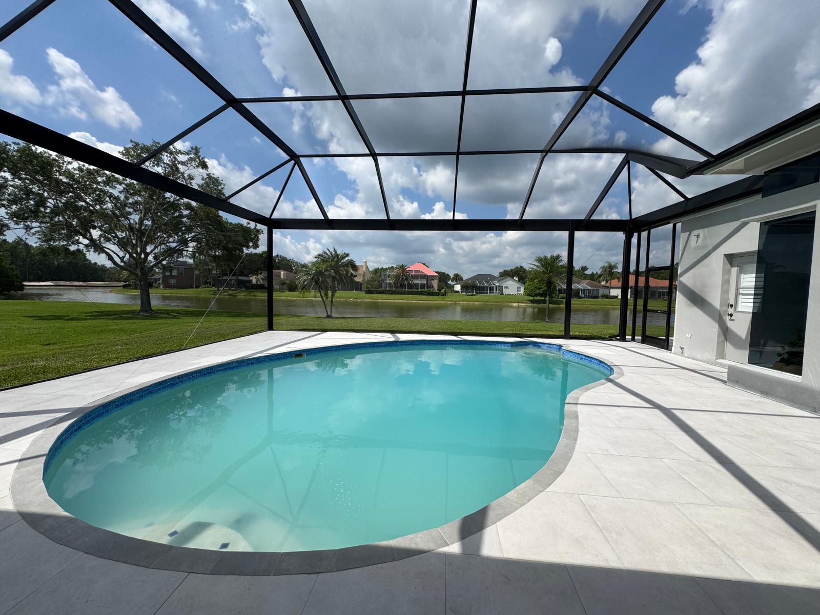 Finished pool terrace overlooking a lawn and lake